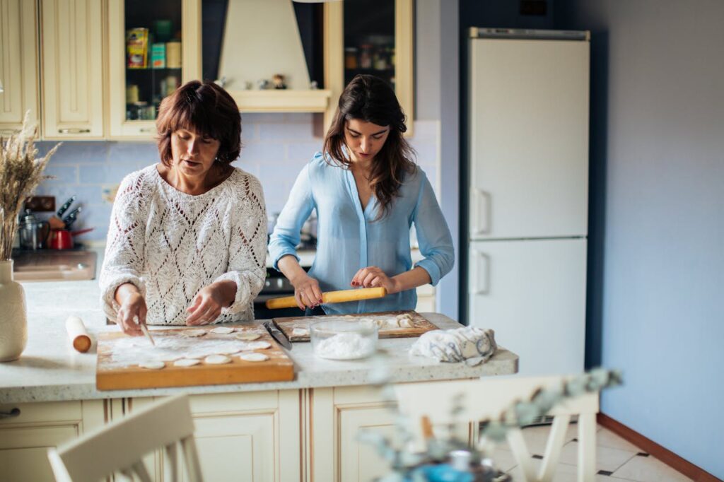 Mother and daughter making traditional Russian pelmeni in a cozy kitchen setting.